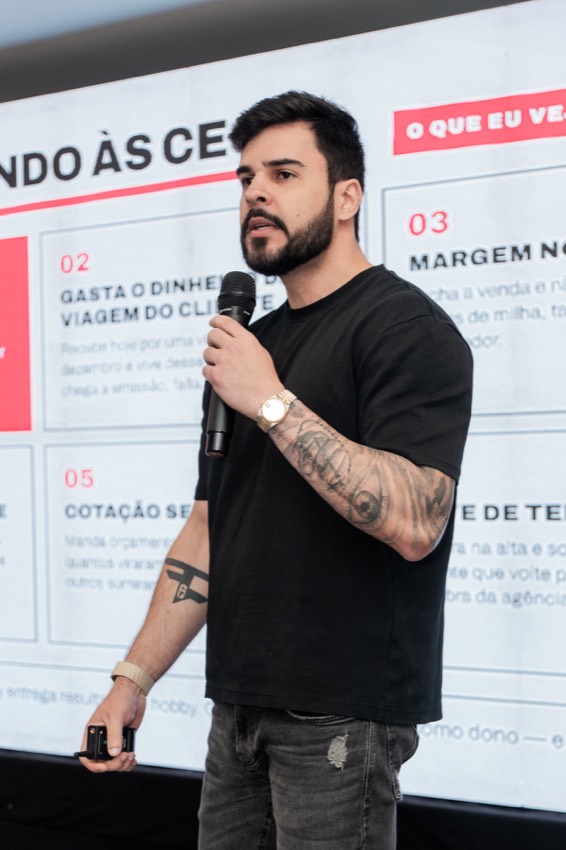 Leandro Portela falando ao microfone em uma apresentação